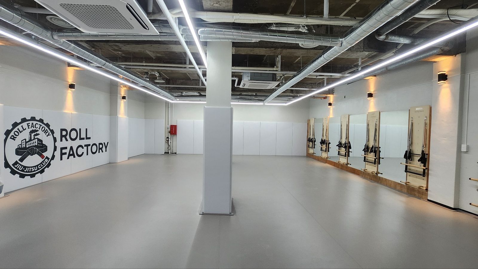 롤팩토리 주짓수 30평 매트 전경 — 수업 전 빈 매트와 ROLL FACTORY 로고 벽면